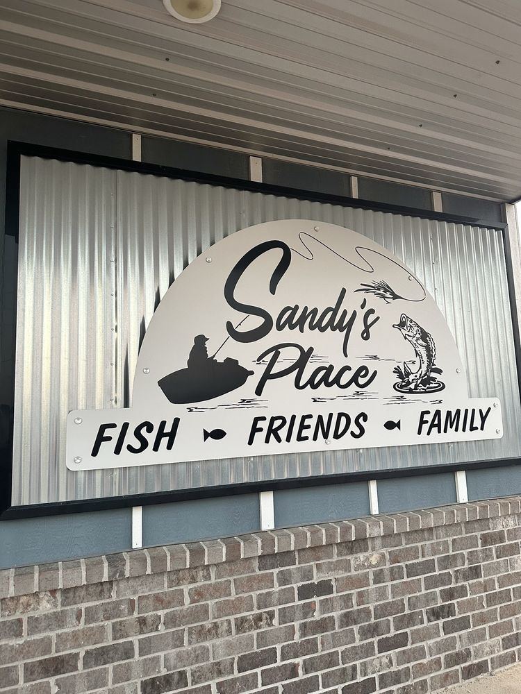 The Sandy's Place sign on the building on Nash Road: Fish, Friends, Family